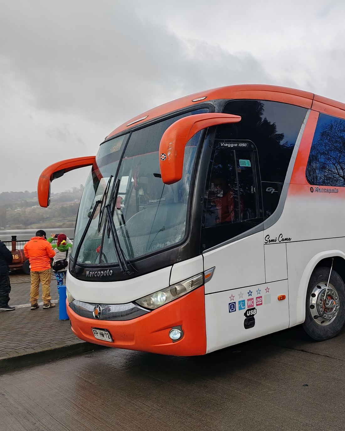 Pasajeros junto a un bus de turismo Danyviajes antes de iniciar el viaje